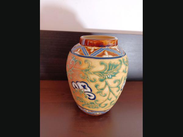 Vase en faïence à décor floral en émaux. Hauteur 21 cm.